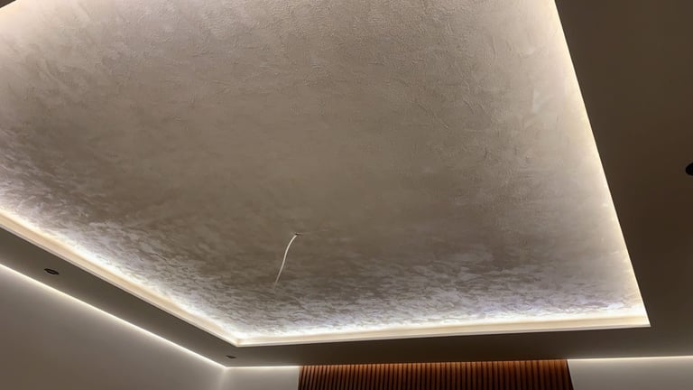 Modern ceiling with recessed LED lighting around the perimeter and textured white center panel